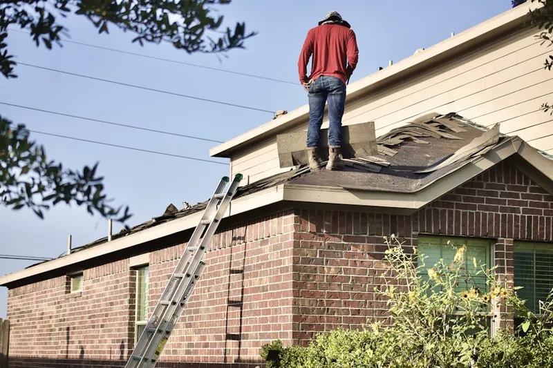 Professional roofer working on a residential roof in Hudson
